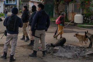 Community police officers and "autodefensas" stand guard.