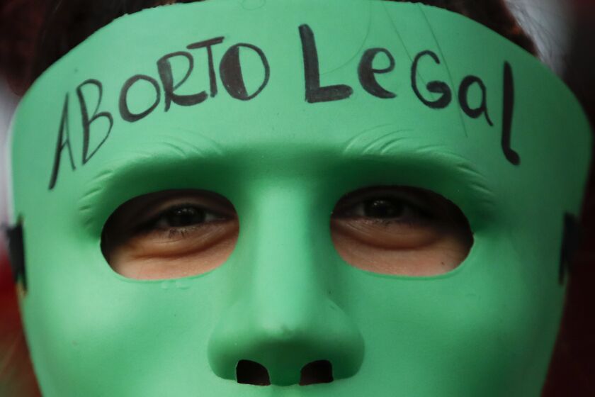 FILE - An abortion-rights activist wears a mask with text that reads in Spanish "Legal Abortion" during a rally outside Congress as lawmakers debate a bill that would legalize abortion, in Buenos Aires, Argentina, Tuesday, Dec. 29, 2020. In Argentina, lawmakers in late 2020, passed a bill legalizing abortion until the 14th week. (AP Photo/Natacha Pisarenko, File)