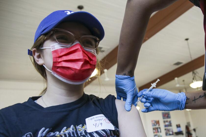 Los Angeles, CA - April 09: Karen Macias, 20, gets a COVID-19 vaccine at a vaccination clinic established by Councilman Curren Price in partnership with St. John's Well Child and Family Center at St. Patrick's Catholic Church on Friday, April 9, 2021 in Los Angeles, CA.(Irfan Khan / Los Angeles Times)