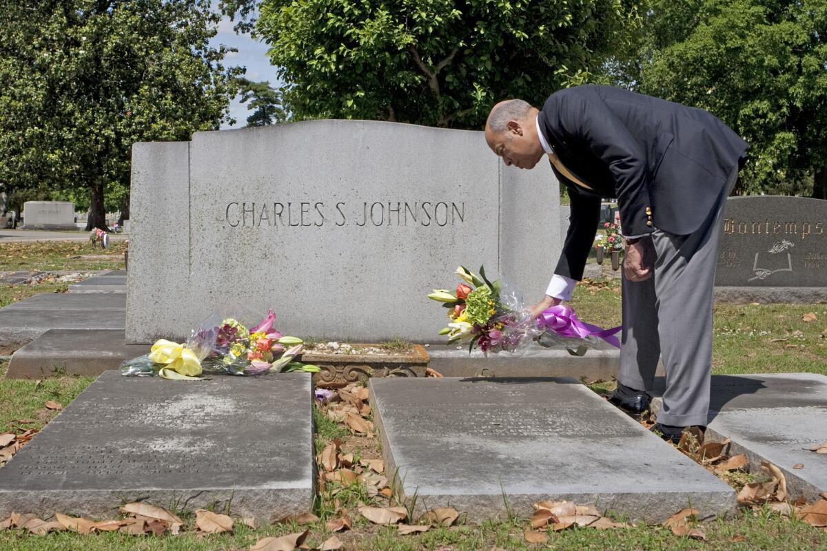 Homeland Security Secretary Jeh Johnson places flowers on his grandparents' graves in Nashville, Tenn. His grandfather Charles S. Johnson was a university president.