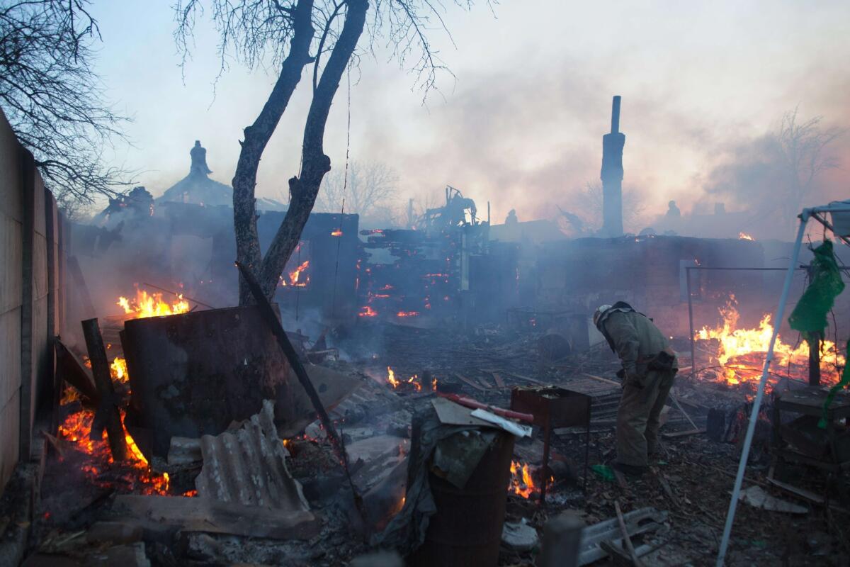 Firefighters tackle a blaze Nov. 20 after shelling destroyed several houses in suburban Donetsk, the main eastern Ukraine flashpoint in a conflict that has taken more than 4,300 lives since April.