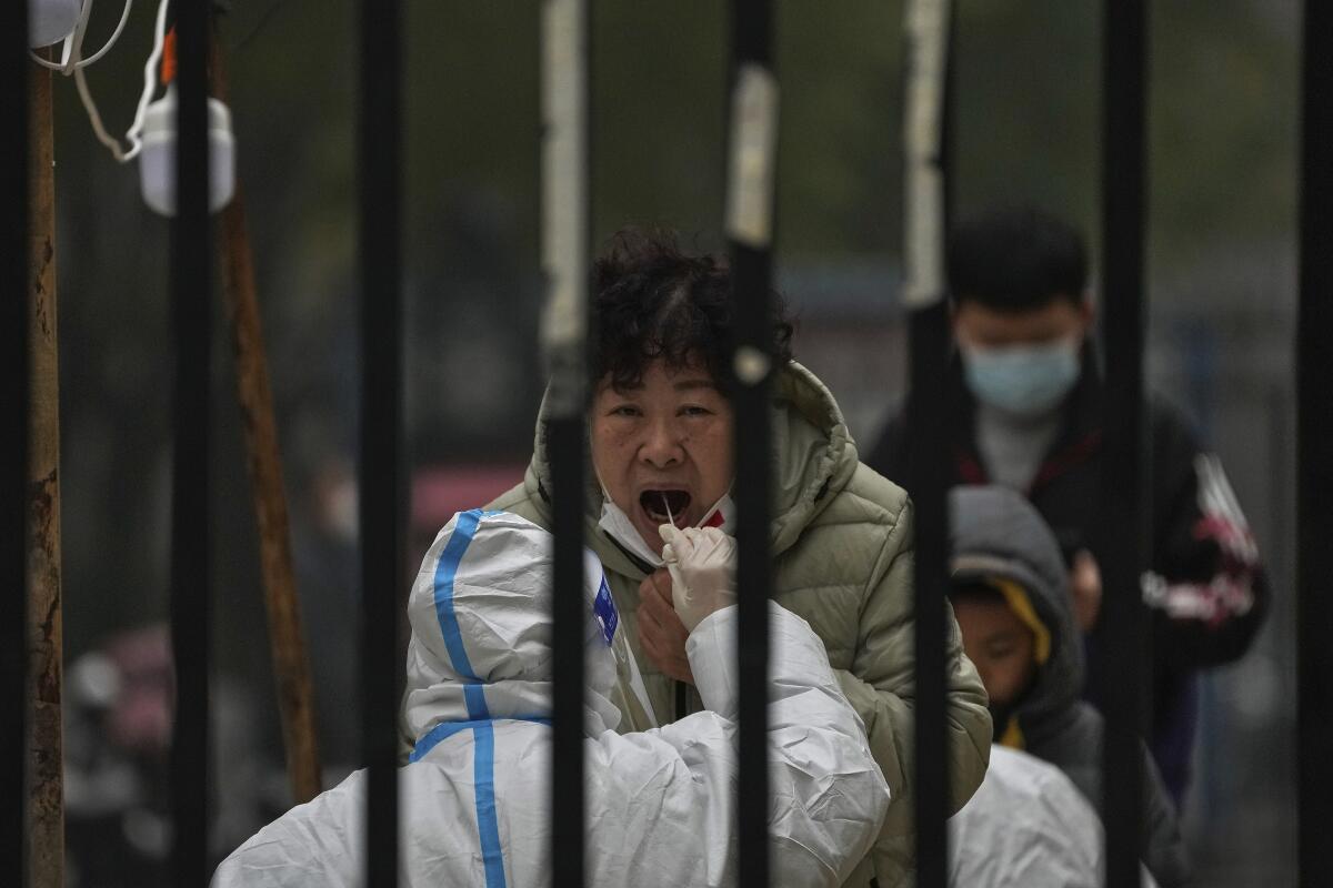 A woman stands in line outdoors being tested for COVID