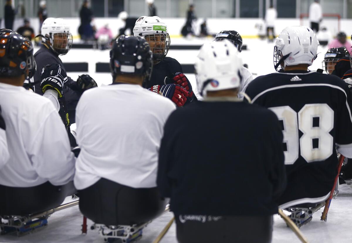 Ralph DeQuebec, center, coaches players during a sled hockey clinic at Great Park Ice rinks in Irvine on Saturday.