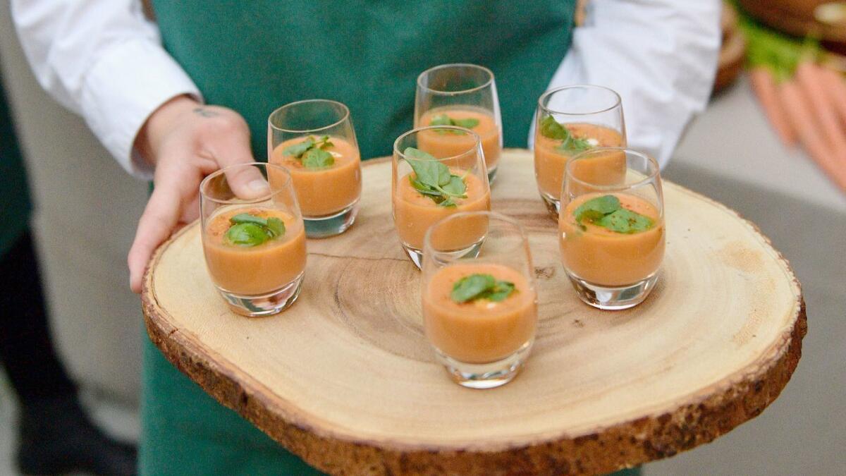 A waiter serves vegan chilled tomato soup with cashew cream at Fayed's cookbook launch party.