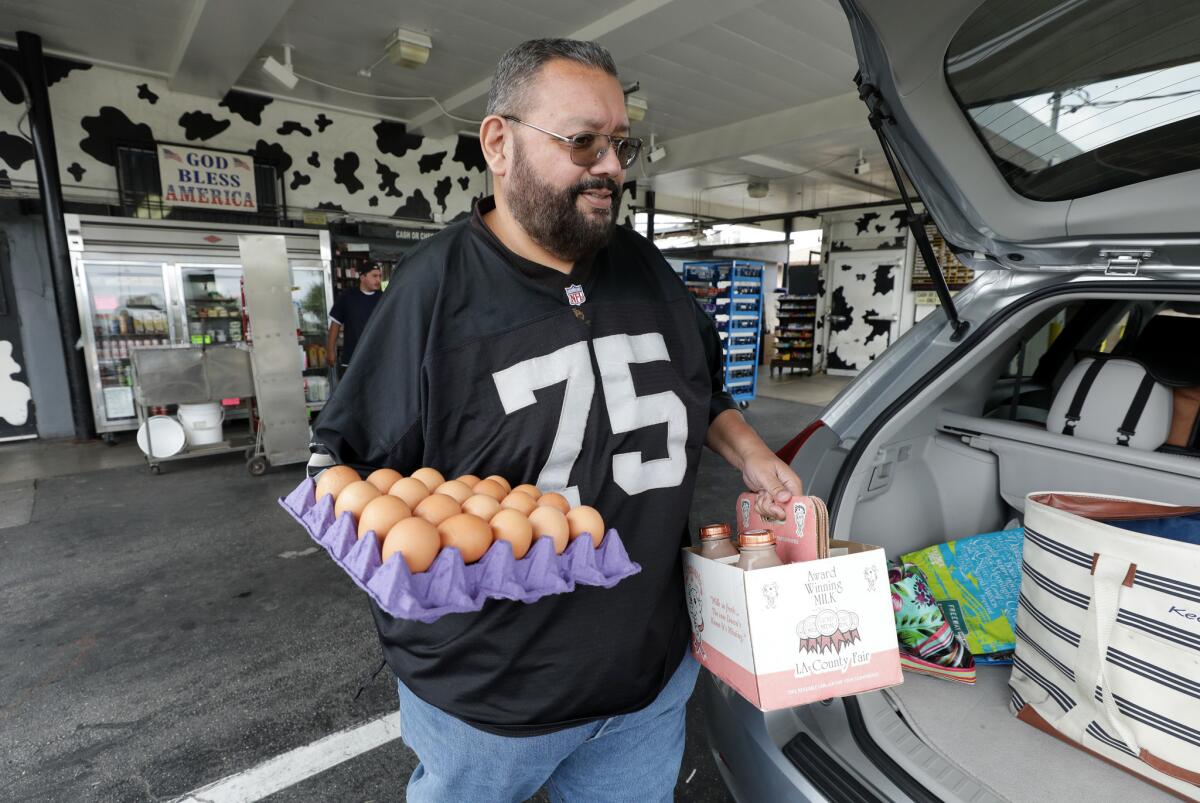 Mike Alcorcha, 63, of Valinda, loads up his car with eggs and milk. He said he's been coming to Broguiere's Dairy since he was a kid.