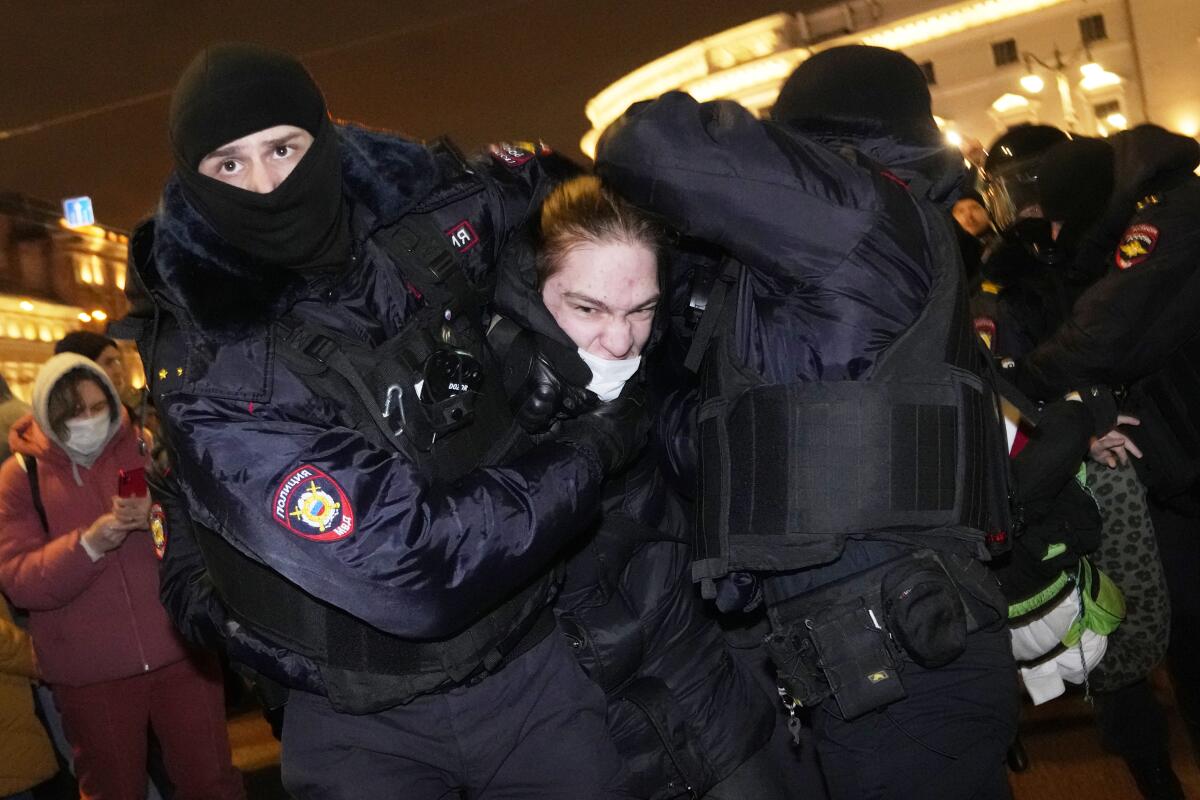 Police officers detain an antiwar demonstrator in St. Petersburg, Russia.