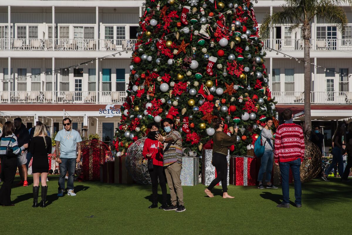 Visitors gather around the Christmas tree at Hotel del Coronado on Dec. 25, 2020.