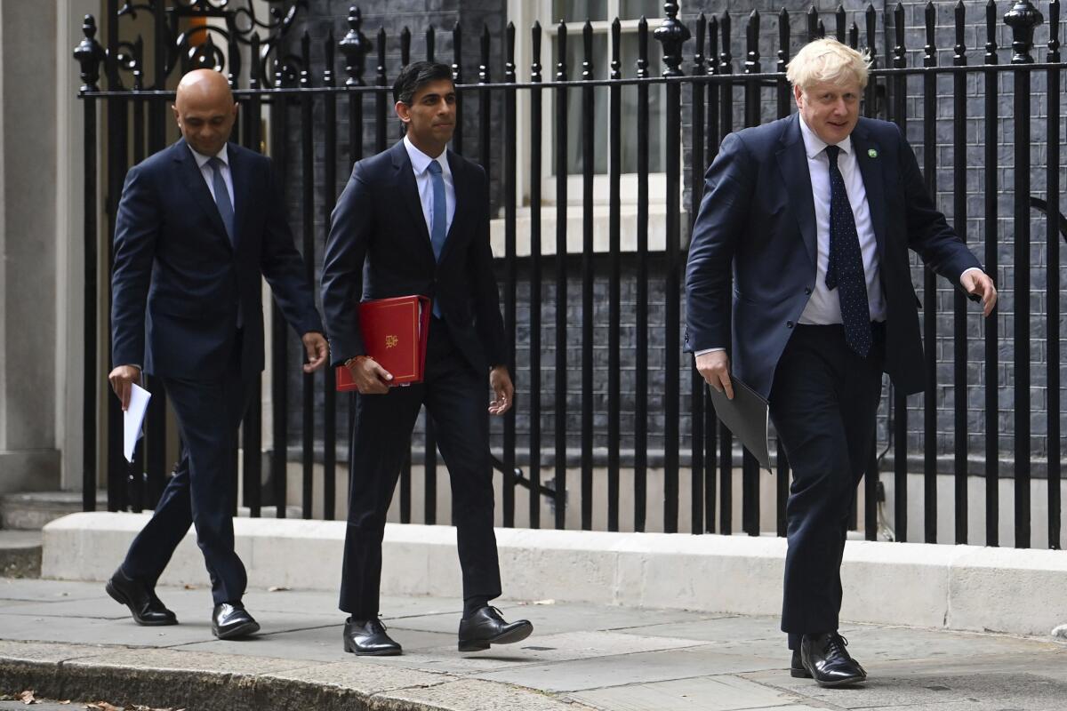 FILE - From left, British Health Secretary Sajid Javid, Chancellor of the Exchequer Rishi Sunak and Prime Minister Boris Johnson arrive at No 9 Downing Street for a media briefing on May 7, 2021. The contest to succeed British Prime Minister Boris Johnson has no single frontrunner but there are many prominent contenders. (Toby Melville/PA via AP, file)