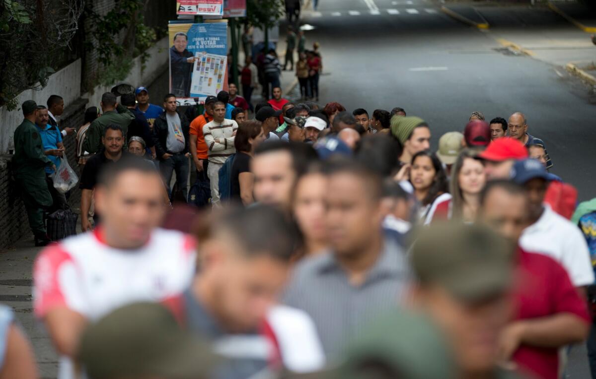 People line up outside a polling station during congressional elections in Caracas, Venezuela, on Sunday.