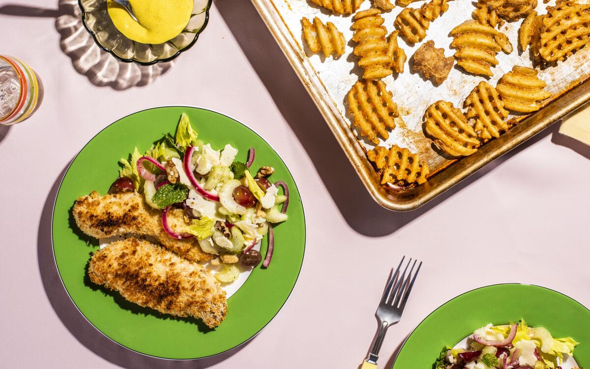 Celery and grapes create a crunchy salad to contrast with hot, crispy baked chicken tenders in this simple weeknight dish.