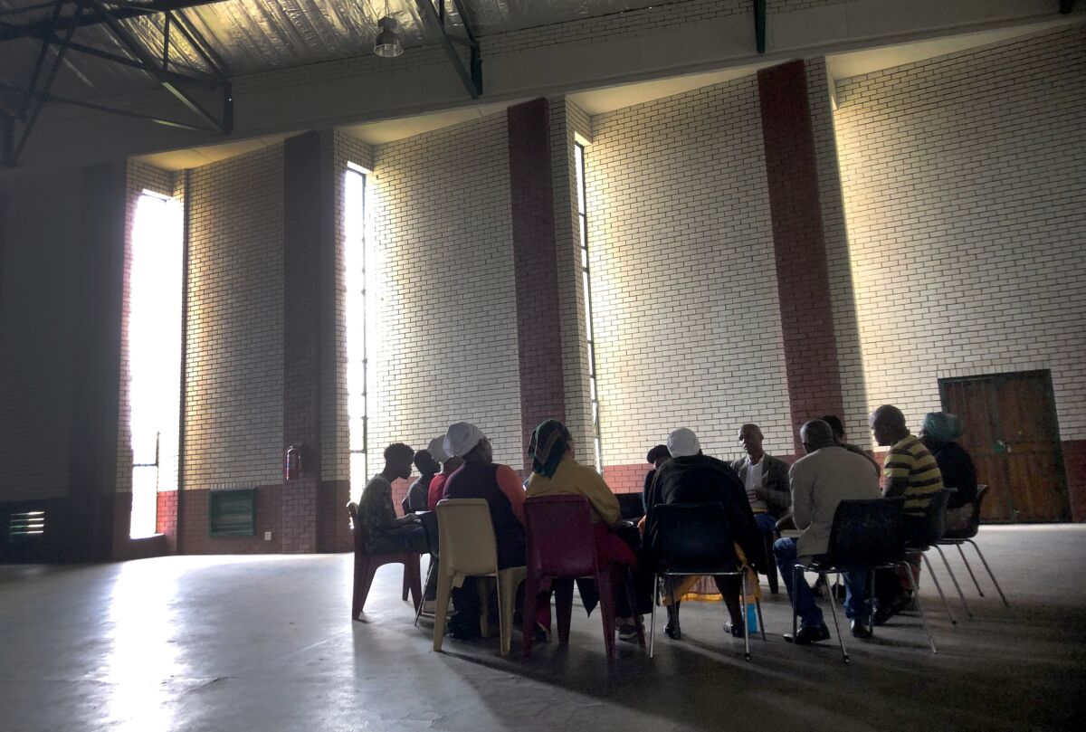 A group meets in a community hall in Brits, South Africa, to talk about drug addiction.