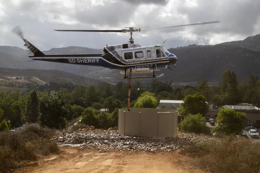 A San Diego County Sheriff's Department firefighting helicopter demonstrates the use of the new Heli-Hydrant water tank at the San Diego Zoo Safari Park.