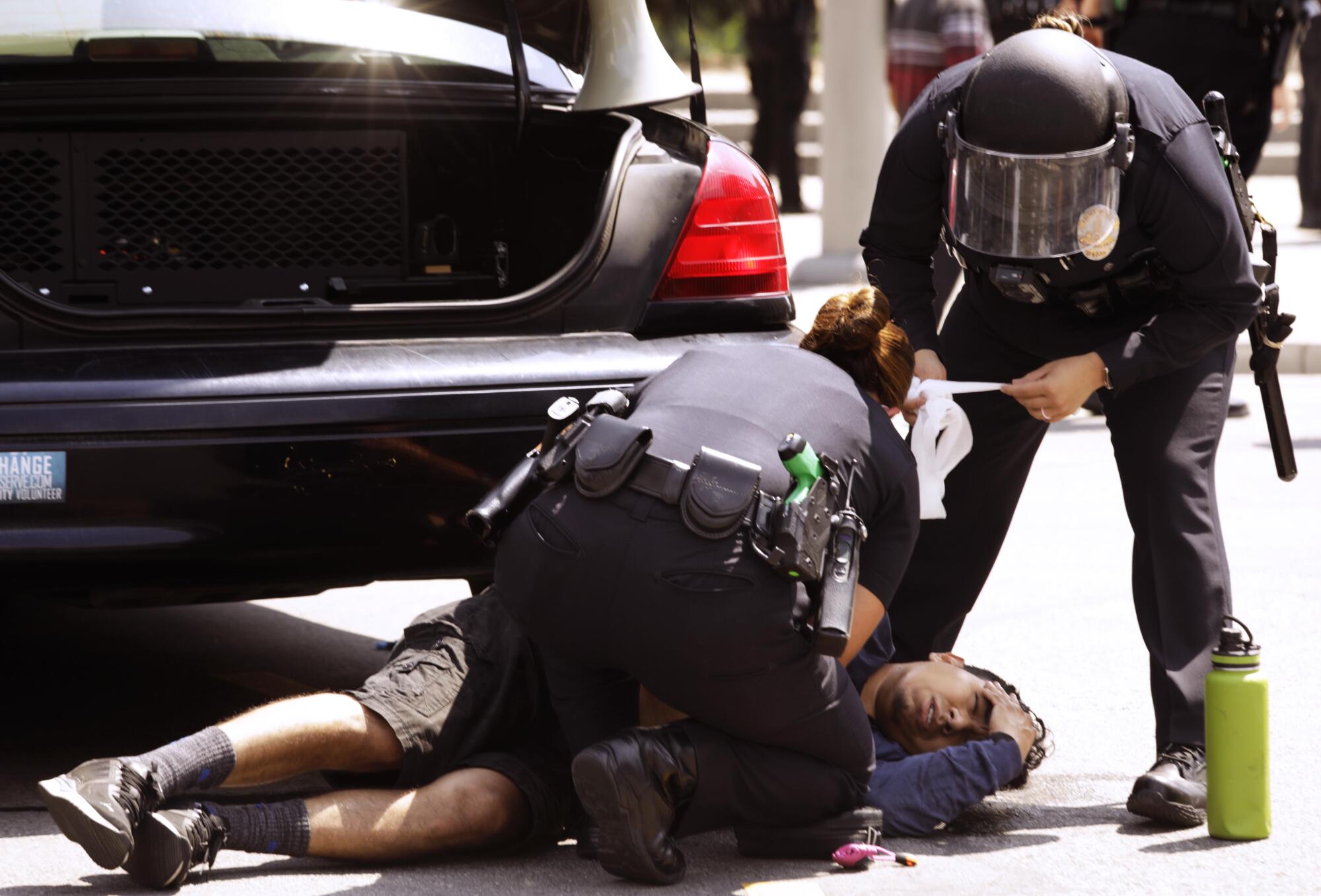 A Los Angeles police officer tries to stop the bleeding of a man who was stabbed.