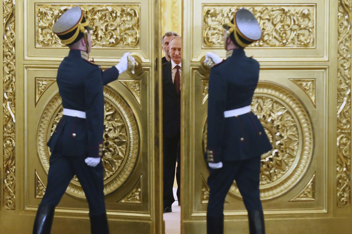 Honor guards open golden doors for Vladimir Putin.