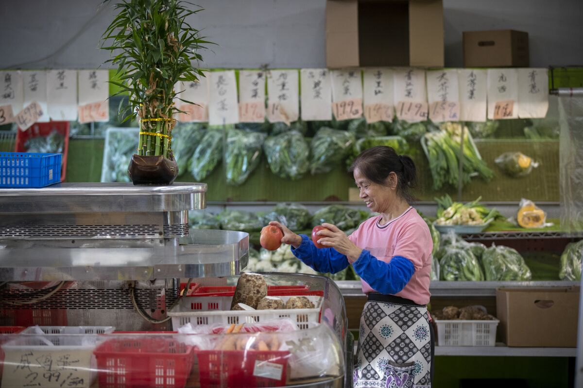 A. Choi arranges fruit on display at G and G Market in Chinatown