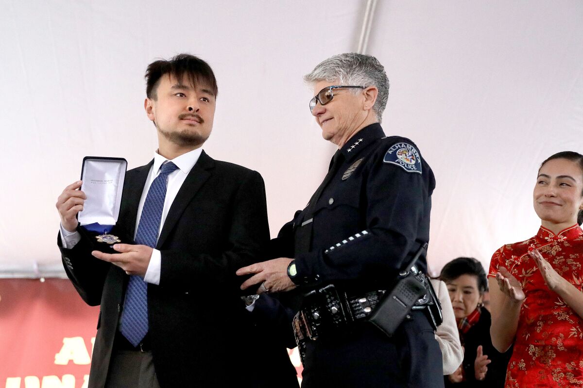 Brandon Tsay holding an Alhambra Police Department Medal for Bravery from Chief of Police Chief Kelley Fraser
