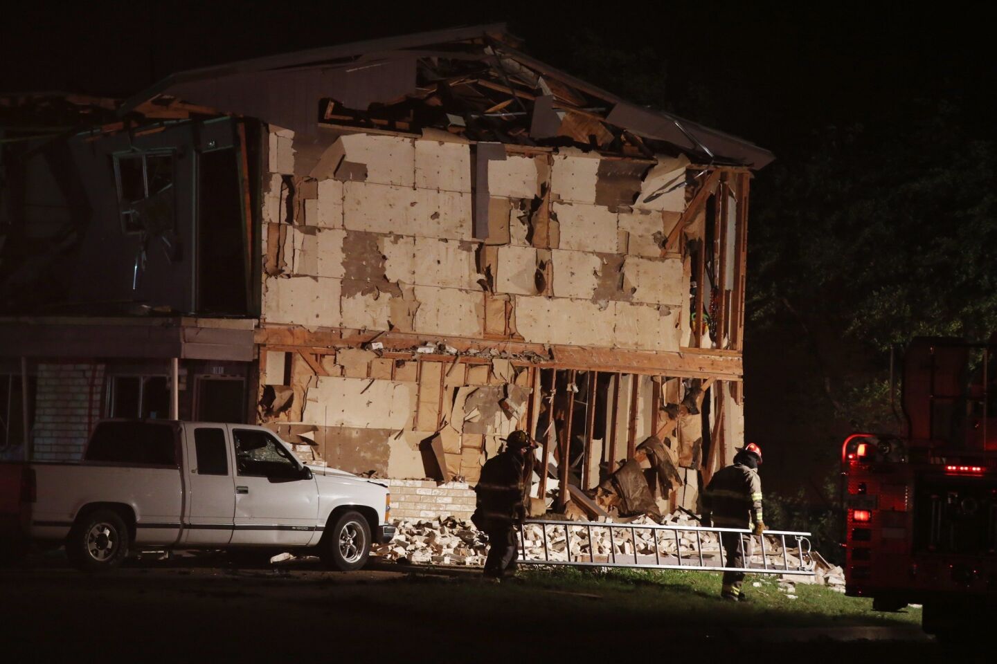 Rescue workers pass a damaged apartment complex after an explosion at a fertilizer plant in West, Texas.