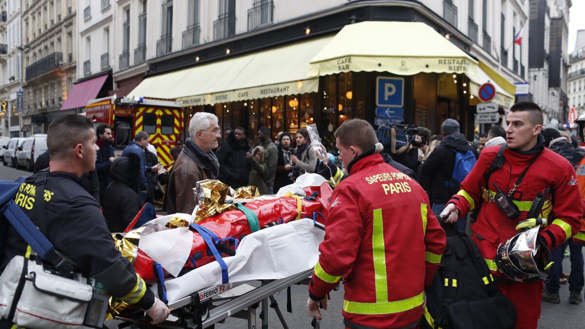 Firefighters remove an injured man after a gas-leak explosion in Paris on Saturday.