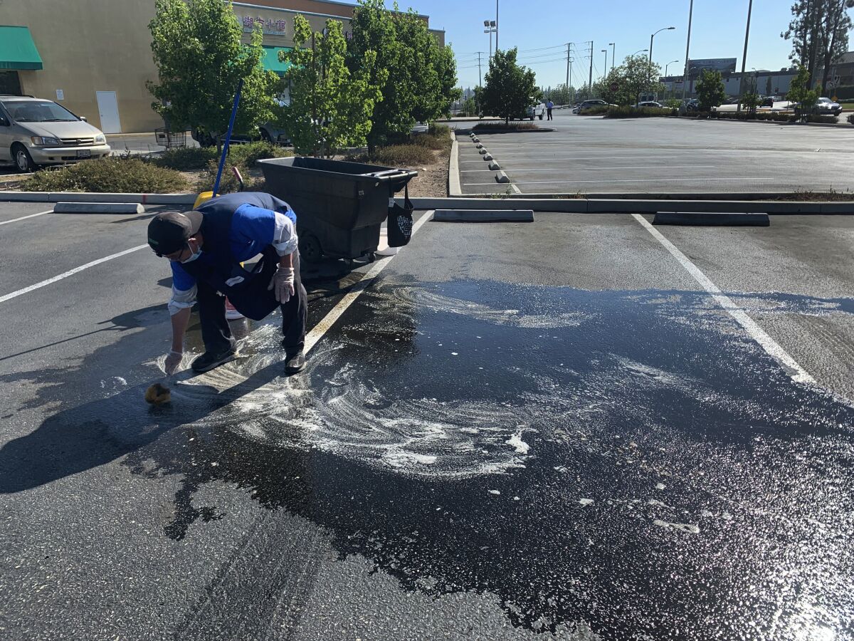 A man scrubs a parking lot