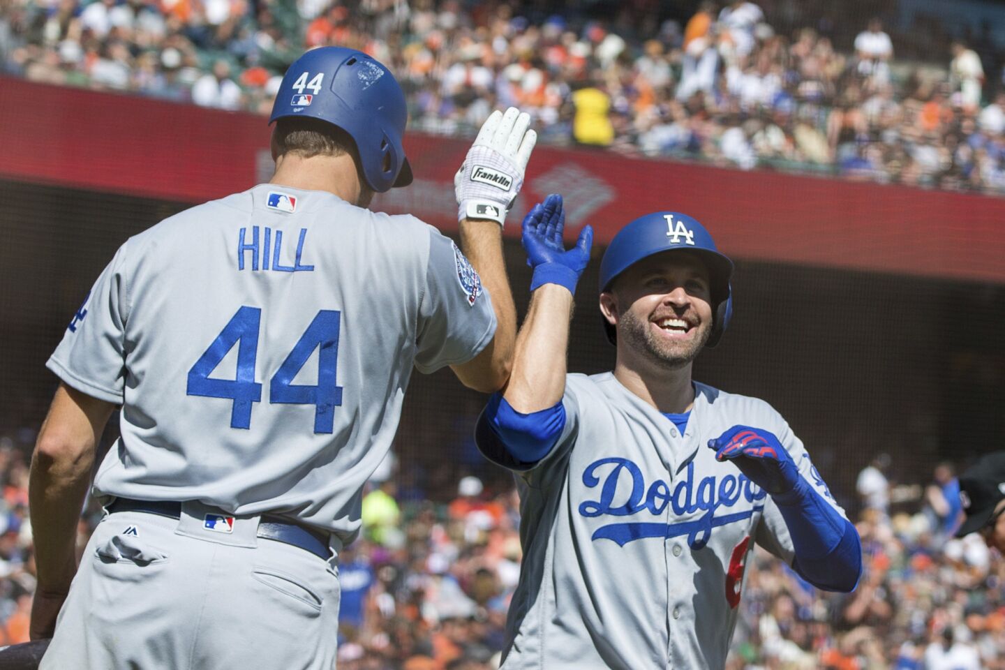 Los Angeles Dodgers Brian Dozier, right, celebrates with Rich Hill (44) after he hit a two-run homer against the San Francisco Giants in the third inning of a baseball game in San Francisco, Sunday, Sept. 30, 2018. (AP Photo/John Hefti)