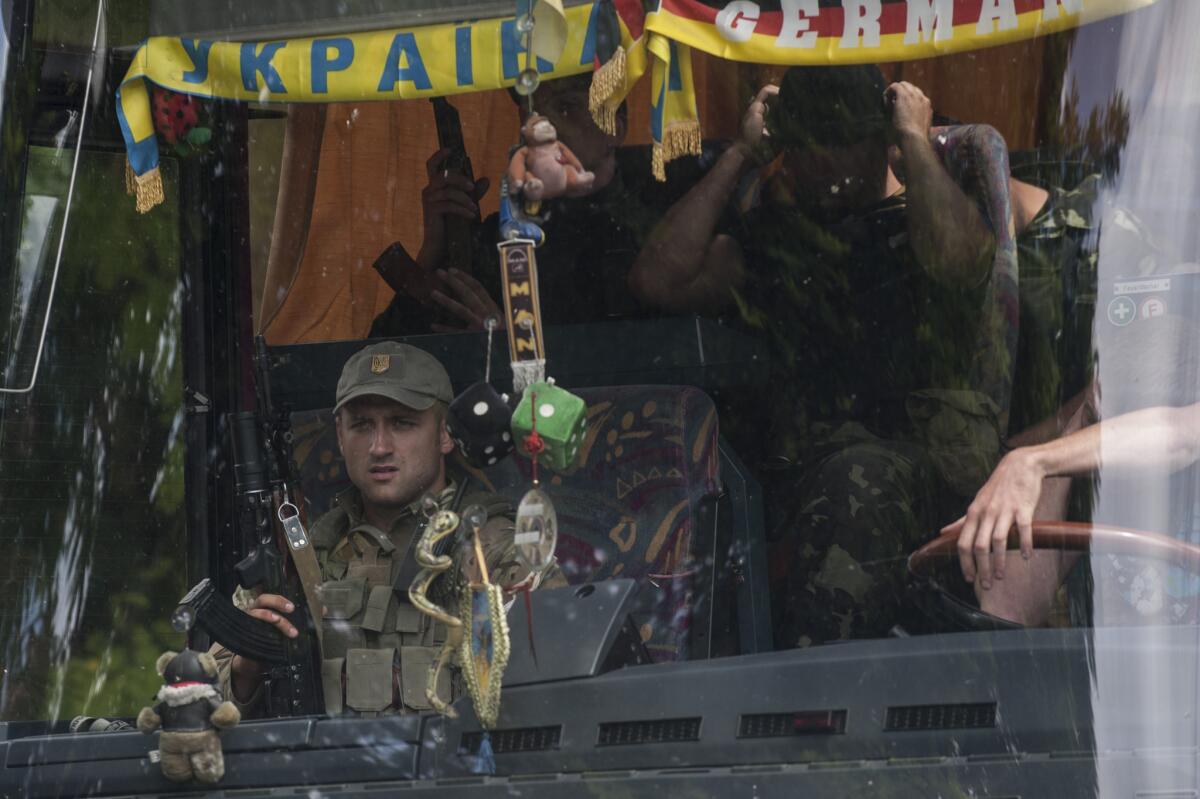 Ukrainian troops photographed through a bus window leave a place of battle in Mariupol, eastern Ukraine, on Friday.