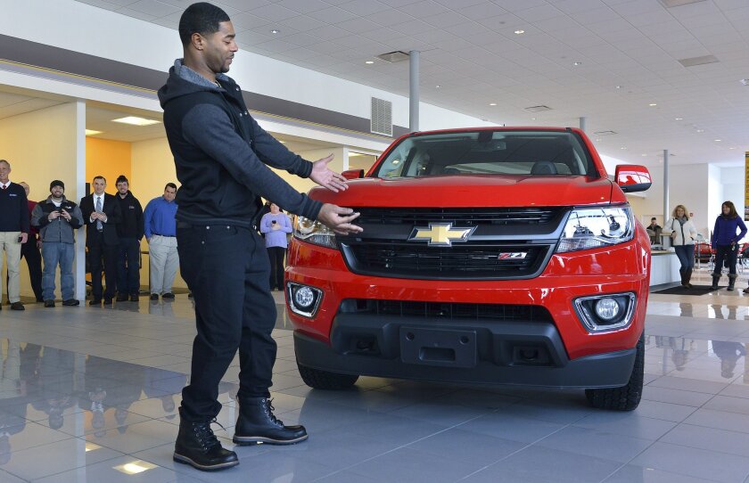 New England Patriots cornerback Malcolm Butler poses with a Chevrolet pickup truck he was presented Tuesday, Feb. 10, 2015, at a dealership in Norwood, Mass. The truck was intended to go to Patriots quarterback Tom Brady as Super Bowl Most Valuable Player. But Brady and the automaker determined that Butler should receive it in recognition for his game-saving interception that clinched the team's Super Bowl XLIX victory. (AP Photo/Josh Reynolds)