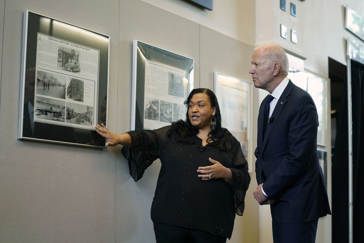 FILE - President Joe Biden listens to program coordinator Michelle Brown-Burdex during a tour of the Greenwood Cultural Center to mark the 100th anniversary of the Tulsa race massacre, Tuesday, June 1, 2021, in Tulsa. Biden, who traveled to Tulsa one year ago to mark the 100th anniversary of the massacre, said Wednesday, June 1, 2022 that his administration has worked to end housing discrimination and to provide federal contracts to businesses owned by Black people. (AP Photo/Evan Vucci File)