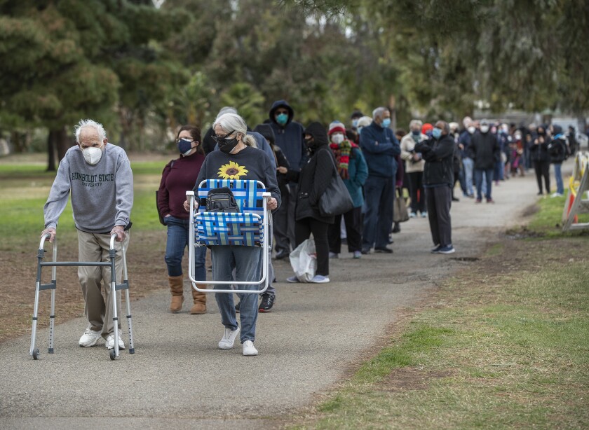 A line of people at the Balboa Sports Complex in Encino arrives for COVID-19 vaccinations.