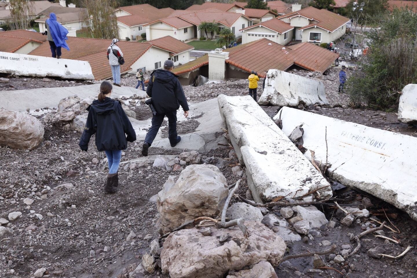 Media look at the debris flow that filled homes and backyards along San Como Lane in Camarillo Springs.