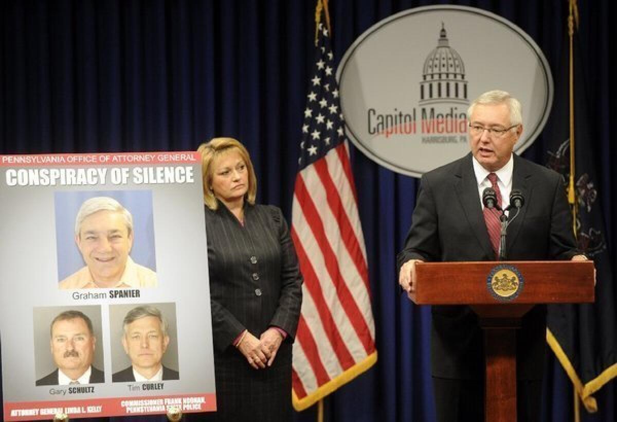 Pennsylvania Attorney General Linda Kelly's office displays a poster of Former Penn State President Graham Spanier, Timothy Curley and Gary Schultz during a news conference Thursday.