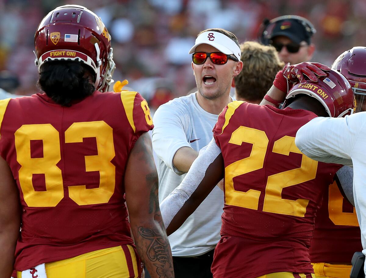 USC coach Lincoln Riley celebrates with his players after the Trojans scored a touchdown.