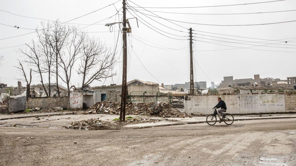 A man bicycles through west Mosul, Iraq.