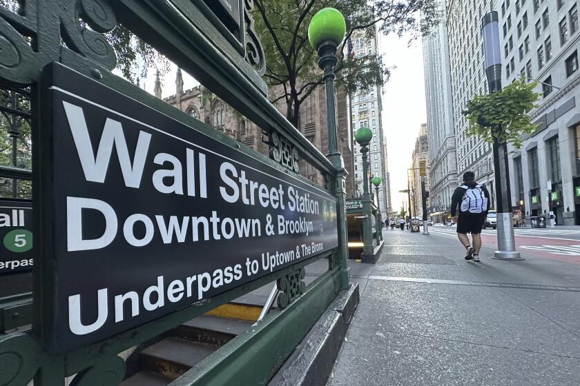 People pass the entrance for the Wall Street subway station on Tuesday, Sept. 2, 2024, in New York. (AP Photo/Peter Morgan)