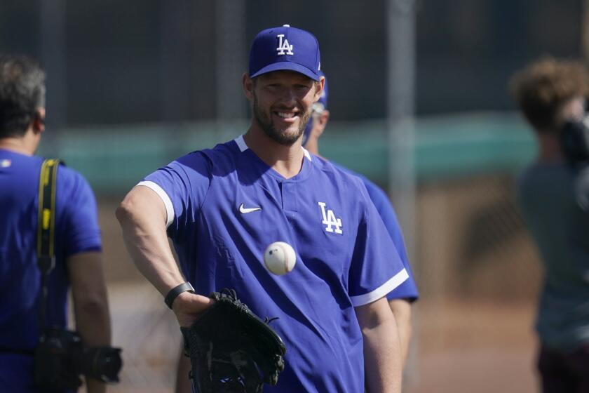 Los Angeles Dodgers starting pitcher Clayton Kershaw reaches out to catch a baseball during baseball spring training Tuesday, Feb. 23, 2021, in Phoenix. (AP Photo/Ross D. Franklin)