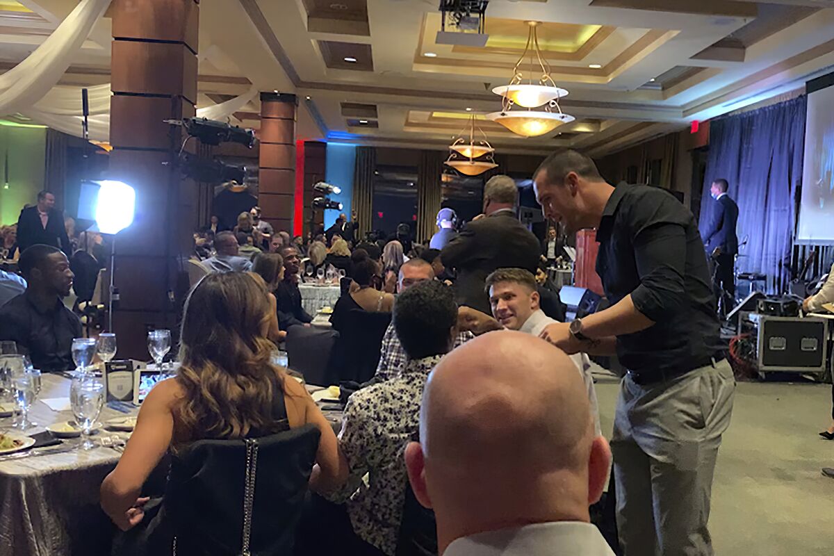 In this still image taken from video, Las Vegas Raiders quarterback Derek Carr, right, meets with people at a charity event held by teammate Darren Waller on Monday, Sept. 28, 2020, in Henderson, Nev. Several Las Vegas Raiders players attended a charity event held by teammate Darren Waller that might have violated league rules for the coronavirus pandemic. The Darren Waller Foundation held a fundraising event at a country club just outside Las Vegas to help young people overcome drug and alcohol addiction. Players were seen on video without masks during the indoor event while talking and mingling with guests, who also weren't wearing masks. (Cassie Soto/Las Vegas Review-Journal via AP)