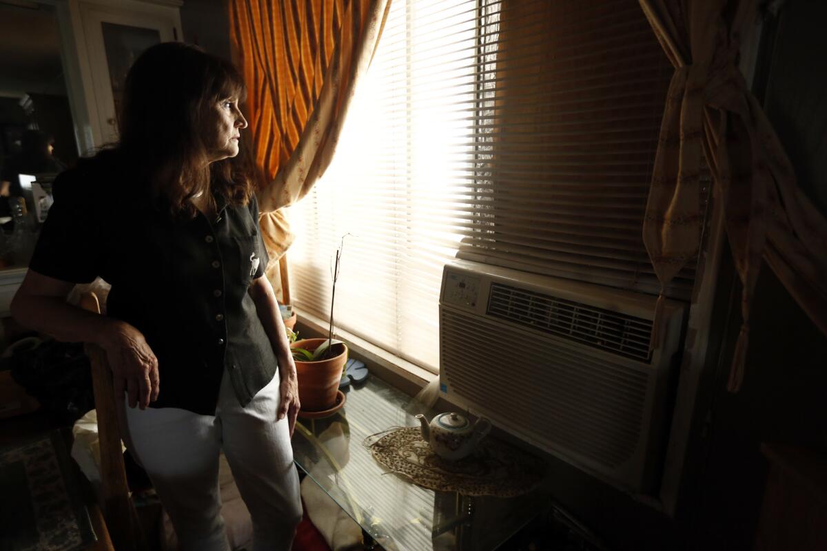 Joan Winget, 75, stands inside her home next to the 5 Freeway in Sun Valley. In an effort to protect herself from car and truck pollution, she keeps her air conditioner on, and her windows closed, around the clock.