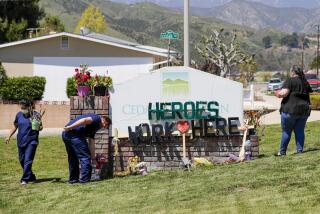 Staff members at Cedar Mountain Post Acute in Yucaipa spruce up a toppled sign that was put up by members of the community to show their support for the nursing staff of the facility.
