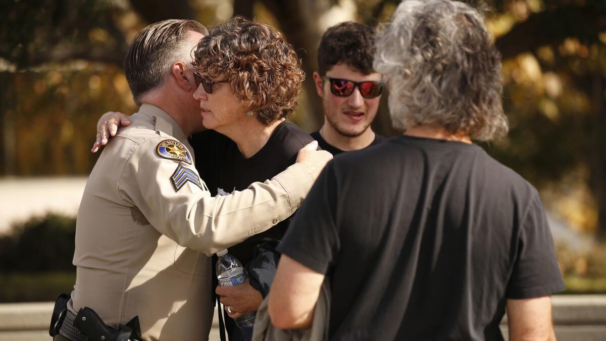 Susan Orfanos, the mother of Borderline shooting victim Telemachus Orfanos, hugs Ventura County Sheriff's Sergeant Eric Buschow, left, with 22-year-old son Tymaeus and husband Marc Orfanos, following the Ventura County Sheriff's Borderline shooting press conference.