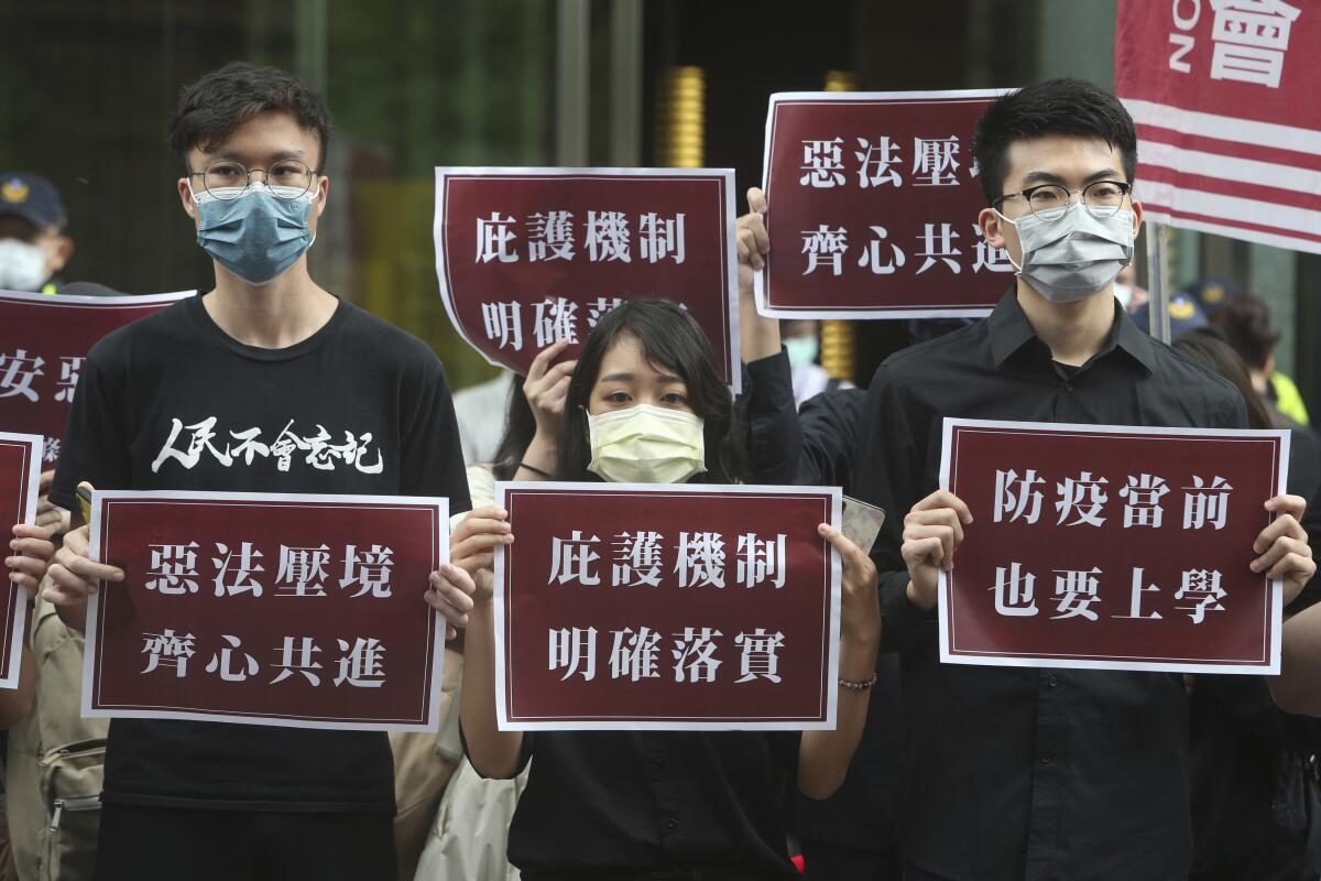 Hong Kong students and Taiwanese supporters hold signs of protest in Taiwan on May 28.