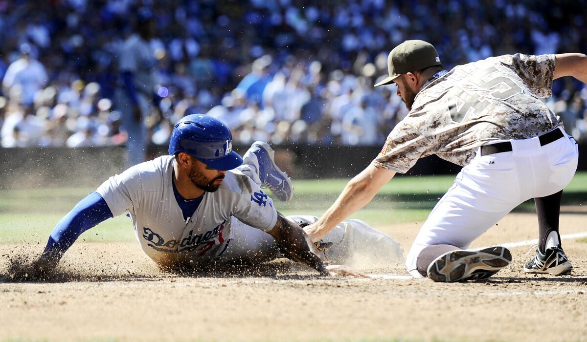 Dodgers right fielder Matt Kemp slides safely into home plate ahead of the tag of Padres pitcher Jesse Hahn during a four-run rally in the eighth inning Sunday in San Diego.