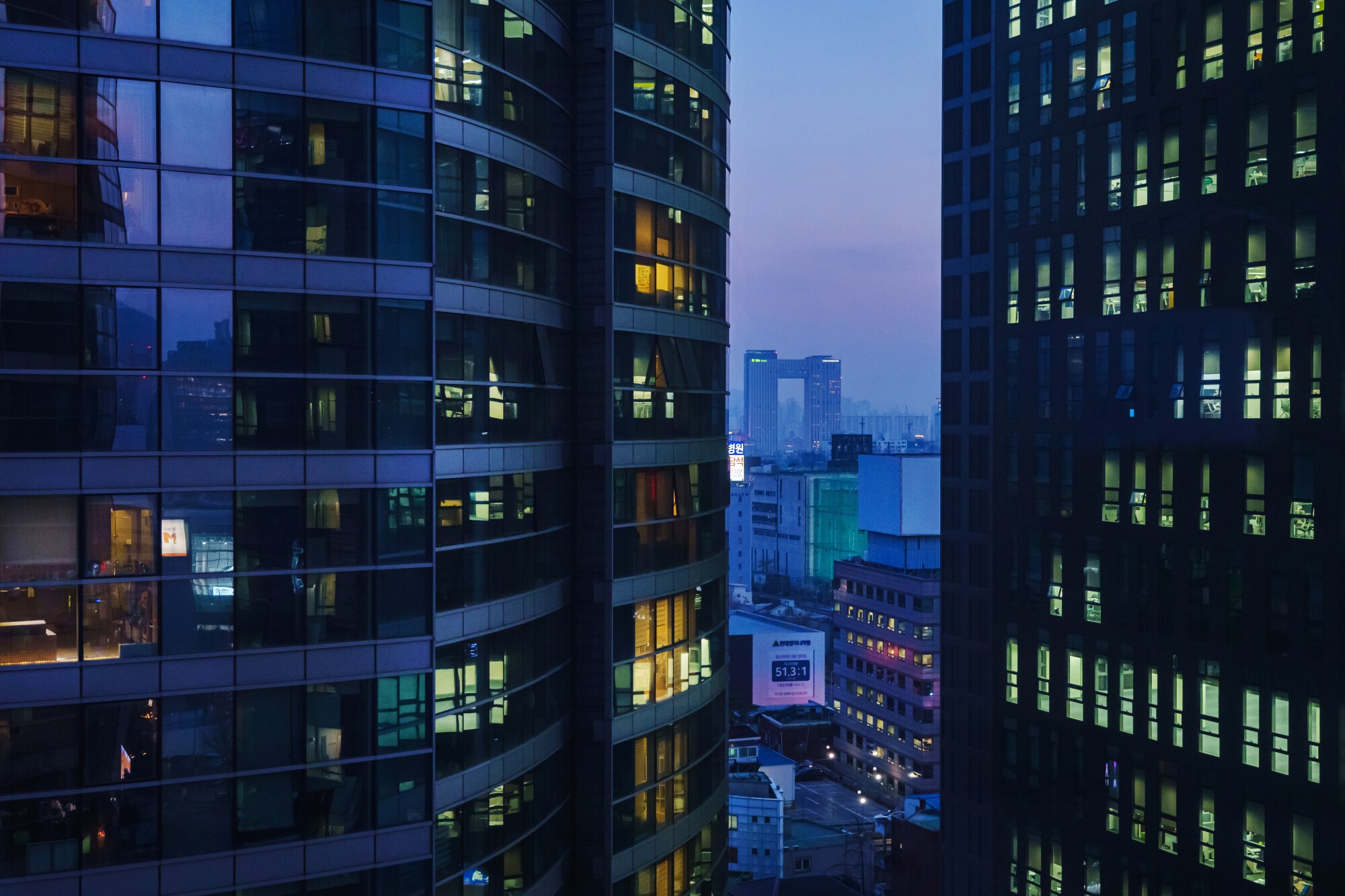 Apartment buildings light up in the evening as people return home from work in Seoul