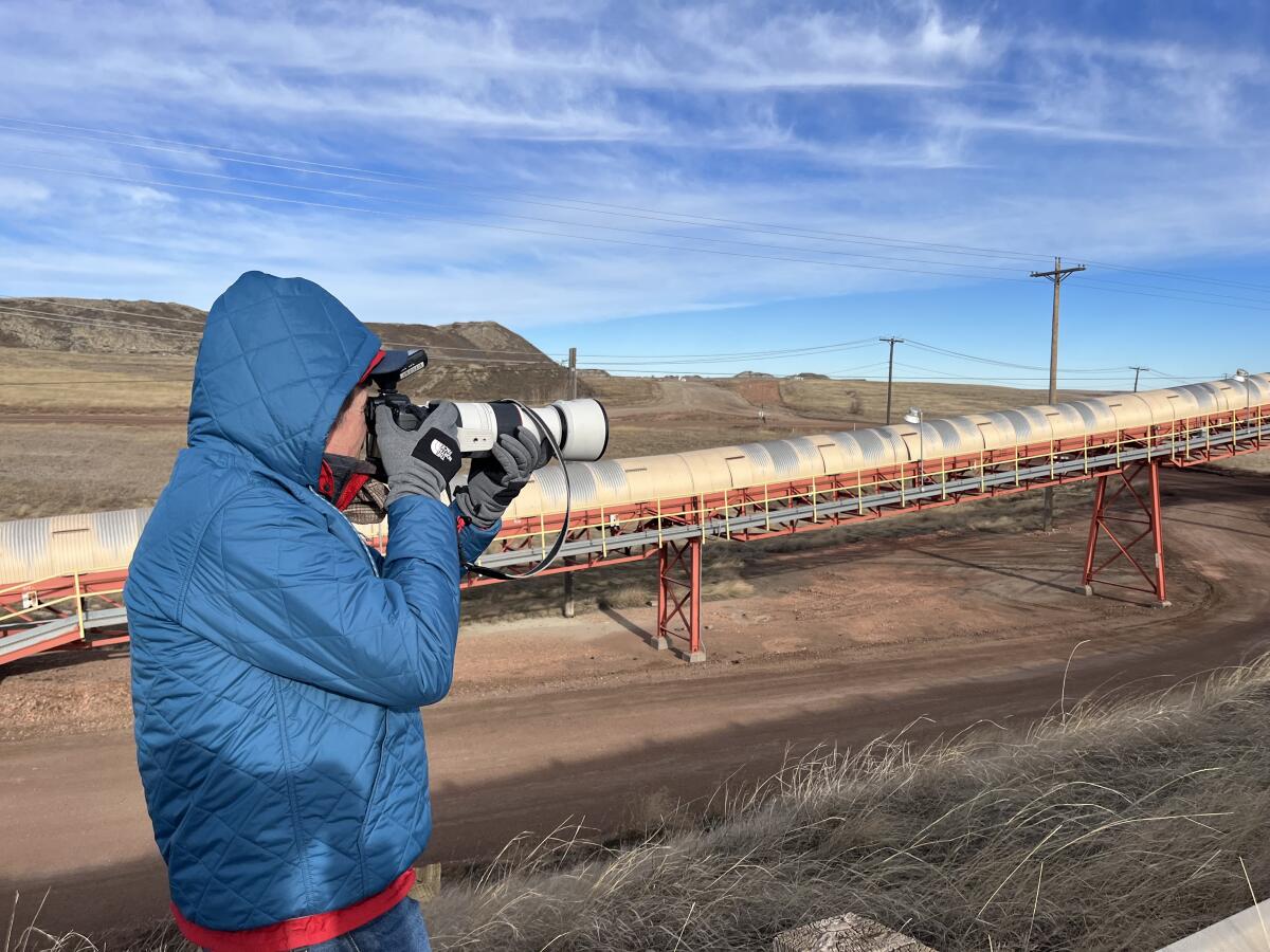L.A. Times photographer Robert Gauthier takes pictures of a conveyor belt that carries coal to the Colstrip power plant.