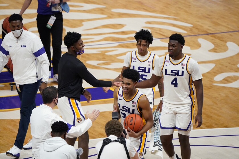 Cam Thomas celebrates LSU's upset win with teammates Eric Gaines (25) and Darius Days (4).