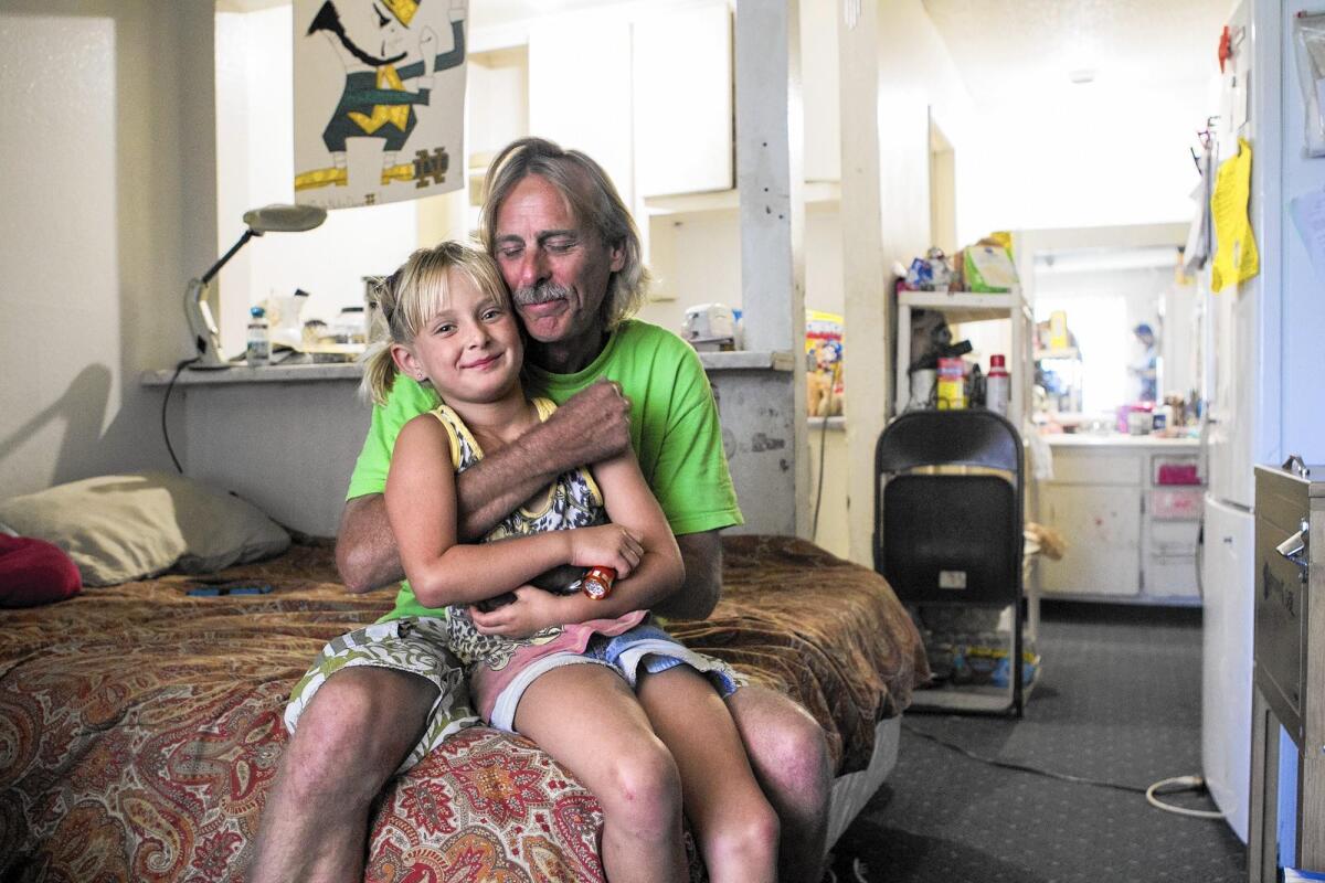 Mike Jensen and his daughter Hallee live in a small room at the Costa Mesa Motor Inn with Jensen’s wife and their two other children. The family’s monthly rate at the Motor Inn is hundreds of dollars less than the typical rent for a one-bedroom apartment in Costa Mesa.