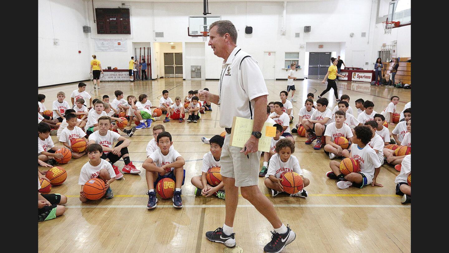 Head coach of the La Cañada basketball team Tom Hofman goes over how he plans to divide up the huge group of campers into smaller groups at the annual Spartan Basketball Camp at La Cañada High School in on Monday, June 12, 2017.