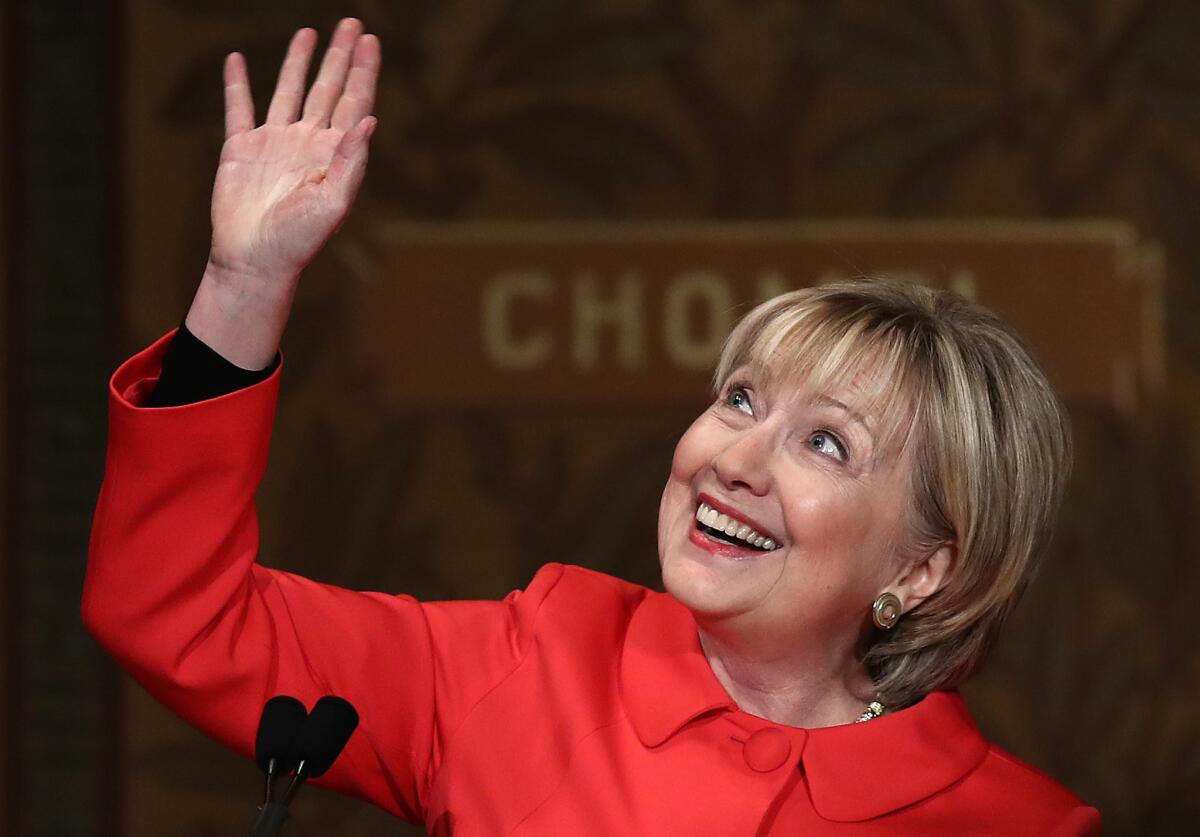 Former U.S. Secretary of State Hillary Clinton waves to students and guests while receiving a standing ovation before delivering remarks at Georgetown University.
