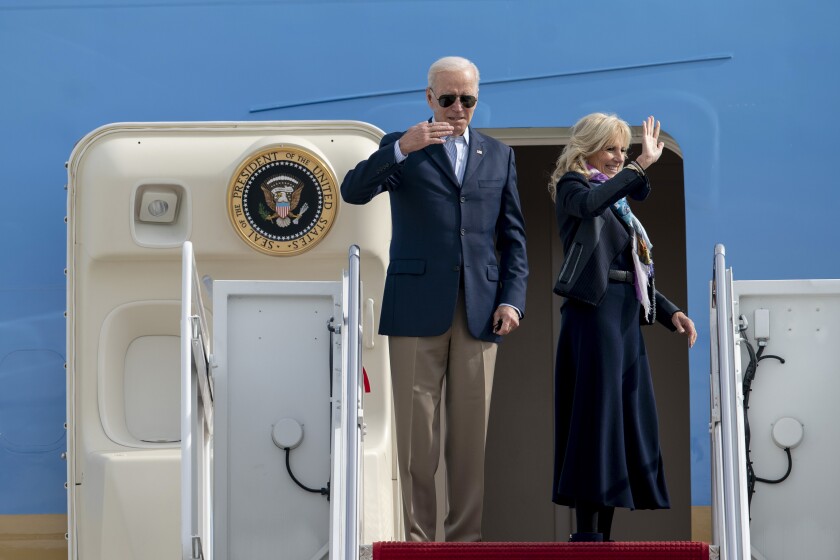Joe Biden y su esposa Jill saludan desde la escalinata del avión presidencial antes de partir rumbo a Europa el 28 de octubre del 2021. (AP Photo/Gemunu Amarasinghe)