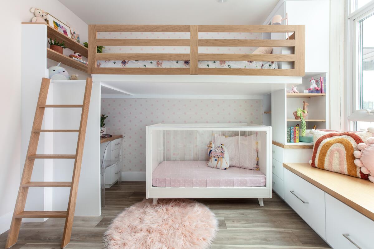 A small bedroom is reconfigured to fit a toddler and her older sister. It has a bunk bed, crib and built-ins for storage.