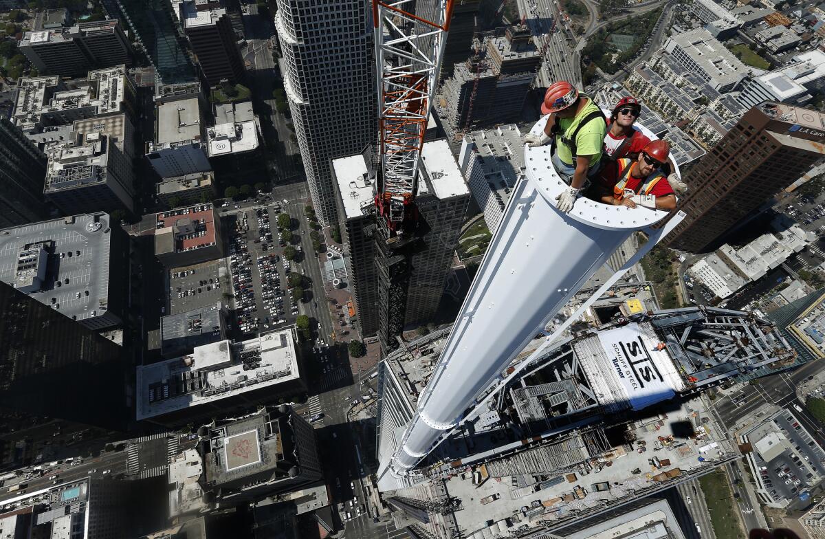 Iron workers are inside a spire attached to the Wilshire Grand Center in downtown Los Angeles. The InterContinental Los Angeles hotel will be part of the center.
