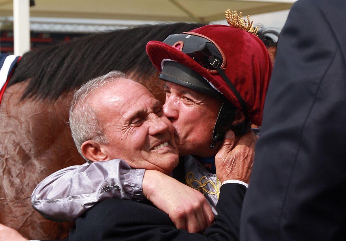 Frankie Dettori dà un bacio sulla guancia a suo padre, Gianfranco, dopo aver vinto il JLT Lockinge Day Stakes nel 2014.